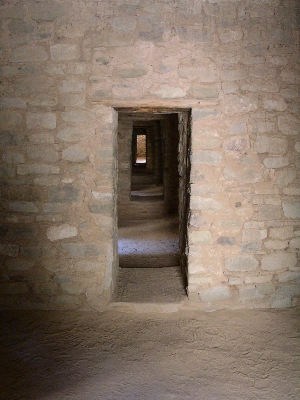 [A series of aligned interior doorways which pass through several rooms and to the outside light at the far end.]